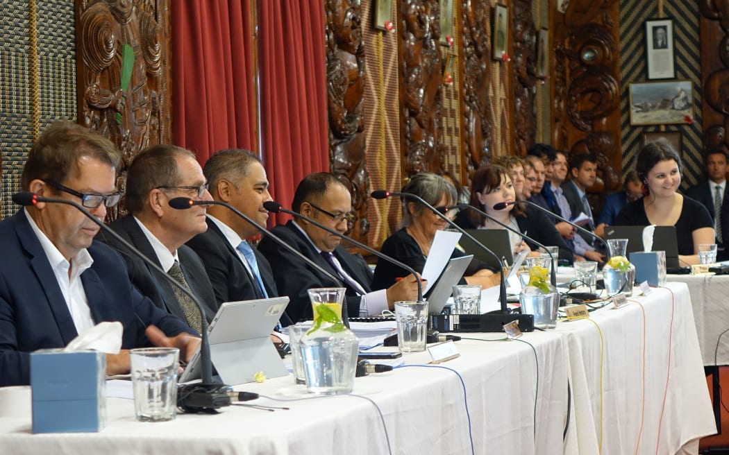 officila sit at long top table in marae