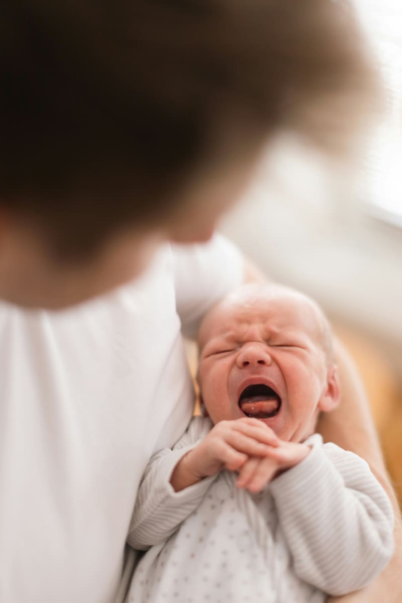Crying baby in mother's arms.