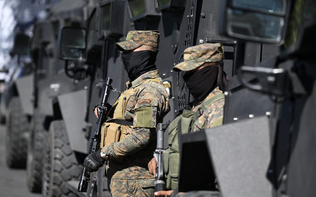 Soldiers stand guard during an operation against gang members in Soyapango, El Salvador, on December 3, 2022. - Around 10,000 Salvadoran army troops and police officers surrounded the populous city of Soyapango, on the outskirts of capital San Salvador, as the government stepped up its fight against criminal gangs, President Nayib Bukele announced Saturday.