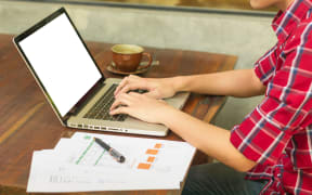 man's hands keyboarding on net-book while sitting at the wooden table in cafe,student working  laptop computer