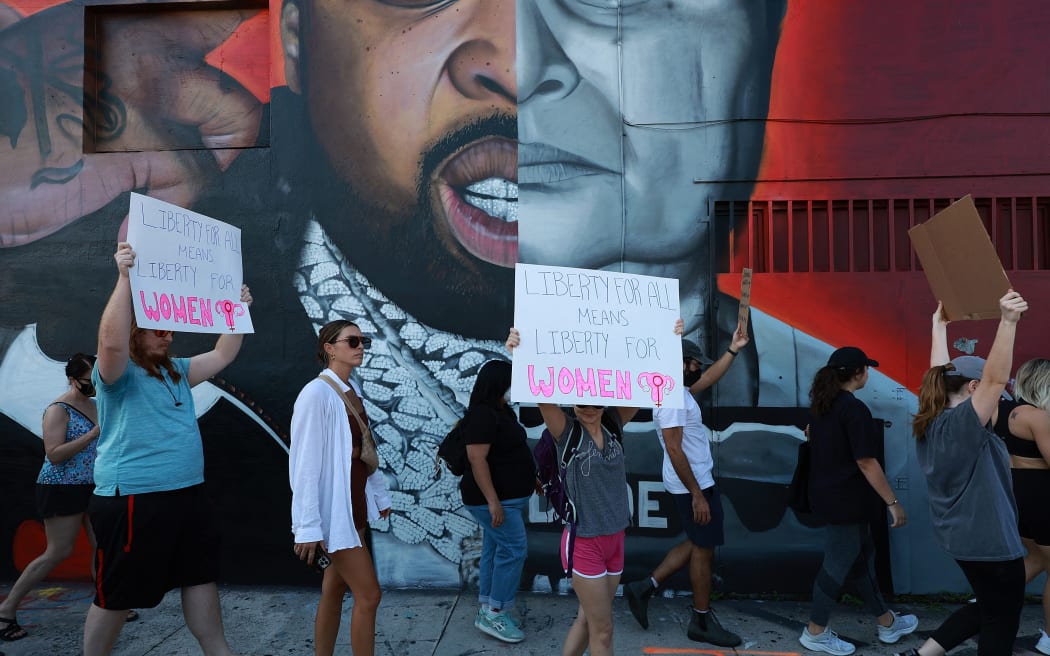 MIAMI, FLORIDA: JUNE 24: People march together to protest the Supreme Court's decision in the Dobbs v Jackson Women's Health case on June 24, 2022 in Miami, Florida. The Court's decision in the Dobbs v Jackson Women's Health case overturns the landmark 50-year-old Roe v Wade case, removing a federal right to an abortion.   Joe Raedle/Getty Images/AFP (Photo by JOE RAEDLE / GETTY IMAGES NORTH AMERICA / Getty Images via AFP)