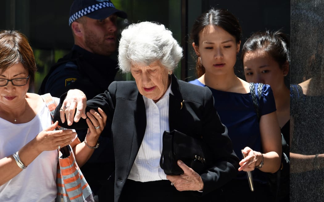 Armed police evacuate office staff next to a cafe in the central business district of Sydney