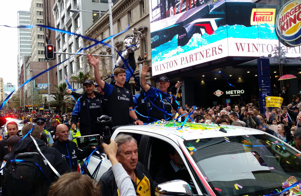 Peter Burling and Team NZ wave to crowds on Queen Street