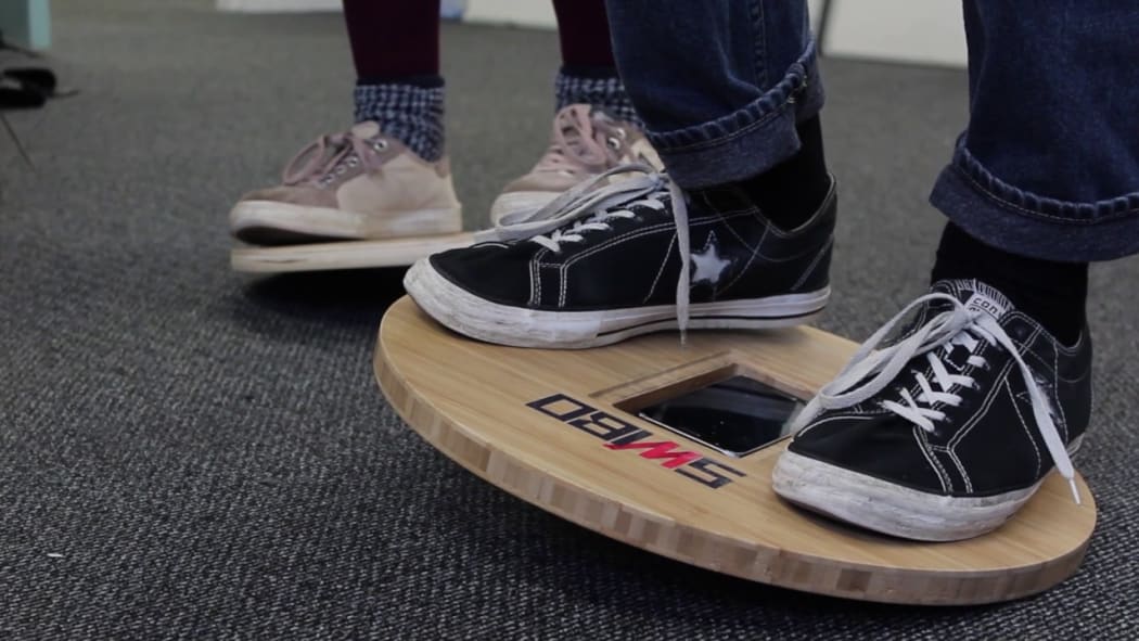 The mobile phone sitting the balance board works as a kind of joystick for the video game.