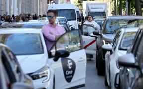 Drivers wait outside their cars in a massive traffic jam in downtown Madrid as subway and trains are totally out of service due to a massive power outage in Spain, on April 28, 2025. Power went out across all of Spain and Portugal today, cutting cellphone and internet networks, halting trains and trapping people in elevators, officials said. The operator, Red Electrica, said it would likely take six to 10 hours to restore power in the country and urged people not to speculate as to the cause of the outage. (Photo by Thomas COEX / AFP)