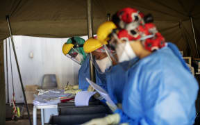 Health workers fill out documents before performing tests for Covid-19 on other health workers at a hospital in Johannesburg,