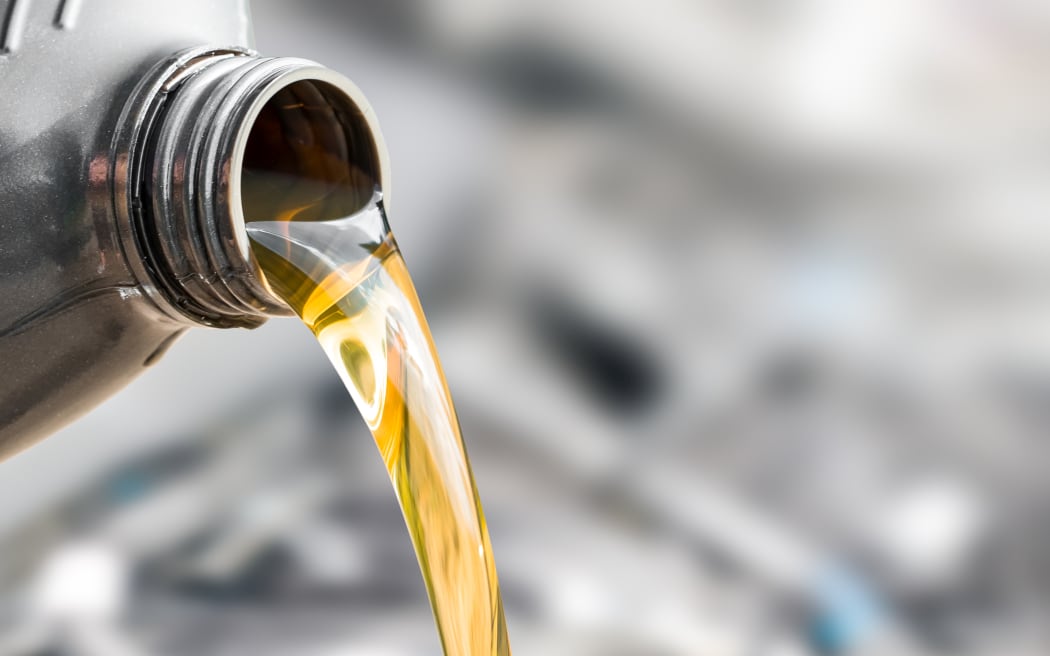 Pouring oil to car engine.