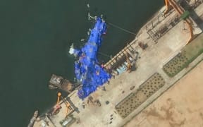 This handout satellite image courtesy of Maxar Technologies taken on May 23, 2025, shows a general view of a new North Korean warship at the harbor after its launch accident in Chongjin. North Korea has begun an investigation into the accident that occurred during the May 21, 2025, launch, state media said on May 23, 2025, assessing the damage as "not serious". (Photo by Handout / Satellite image ©2025 Maxar Technologies / AFP) / RESTRICTED TO EDITORIAL USE - MANDATORY CREDIT "AFP PHOTO/ SATELLITE IMAGE ©2025 MAXAR TECHNOLOGIES" - NO MARKETING NO ADVERTISING CAMPAIGNS - DISTRIBUTED AS A SERVICE TO CLIENTS - THE WATERMARK MAY NOT BE REMOVED/CROPPED