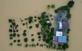 An aerial view shows a home surrounded by flood waters in Kangar in northern Malaysia's Perlis state on November 27, 2025.