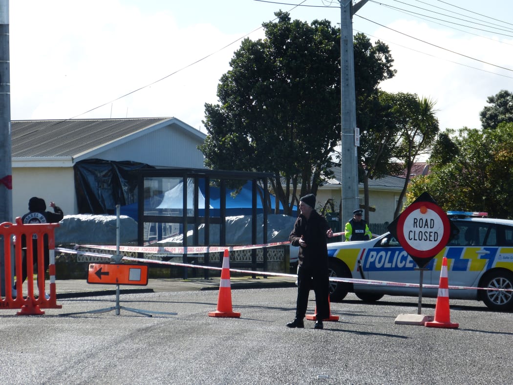 Police and members of the public at a cordon around the scene of the 21 August shooting.