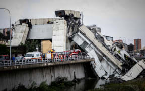 Rescue workers on a part of a Morandi motorway bridge after a section collapsed earlier in Genoa.