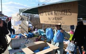 A Hungarian volunteer works at a booth where drinks and other goods are offered to Ukrainian refugees crossing the Ukrainian-Hungarian border in Tiszabecs, Hungary, on February 27, 2022.