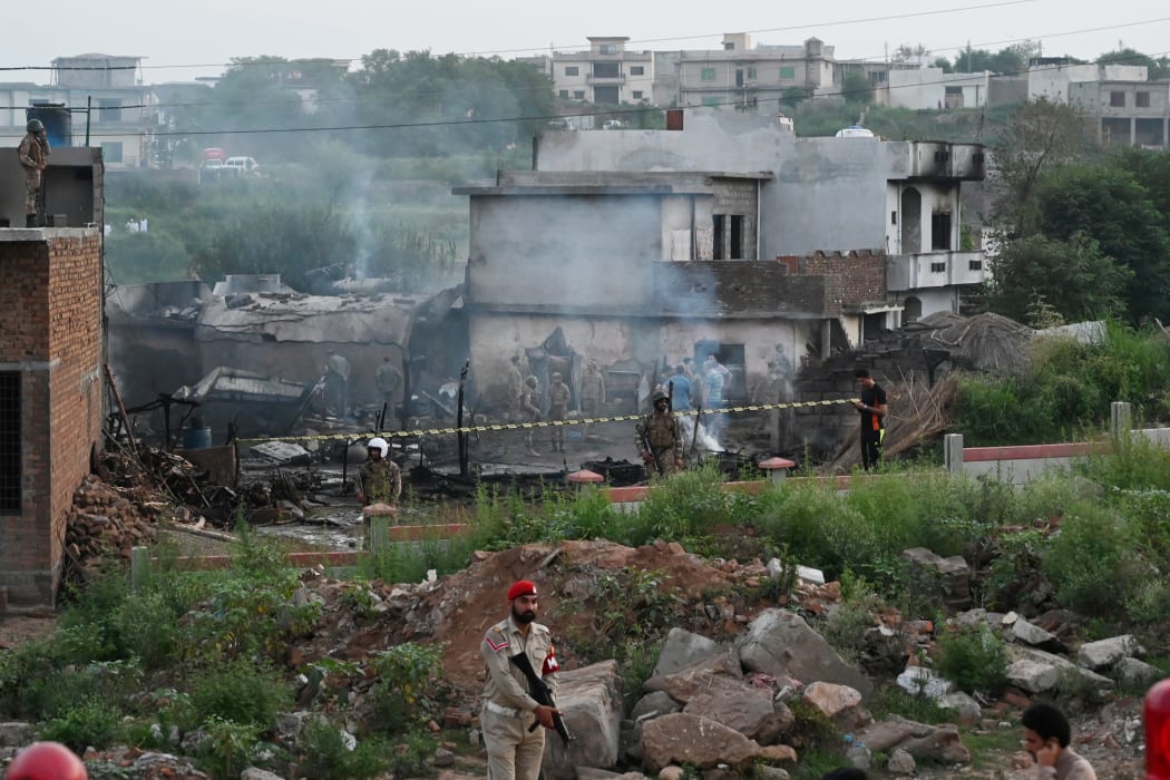 Military personnel work at the scene where a Pakistani Army Aviation Corps aircraft crashed in Rawalpindi on July 30, 2019. - Fifteen people were killed when a small plane crashed into a residential area in the Pakistani city of Rawalpindi near the capital Islamabad. (Photo by AAMIR QURESHI / AFP)