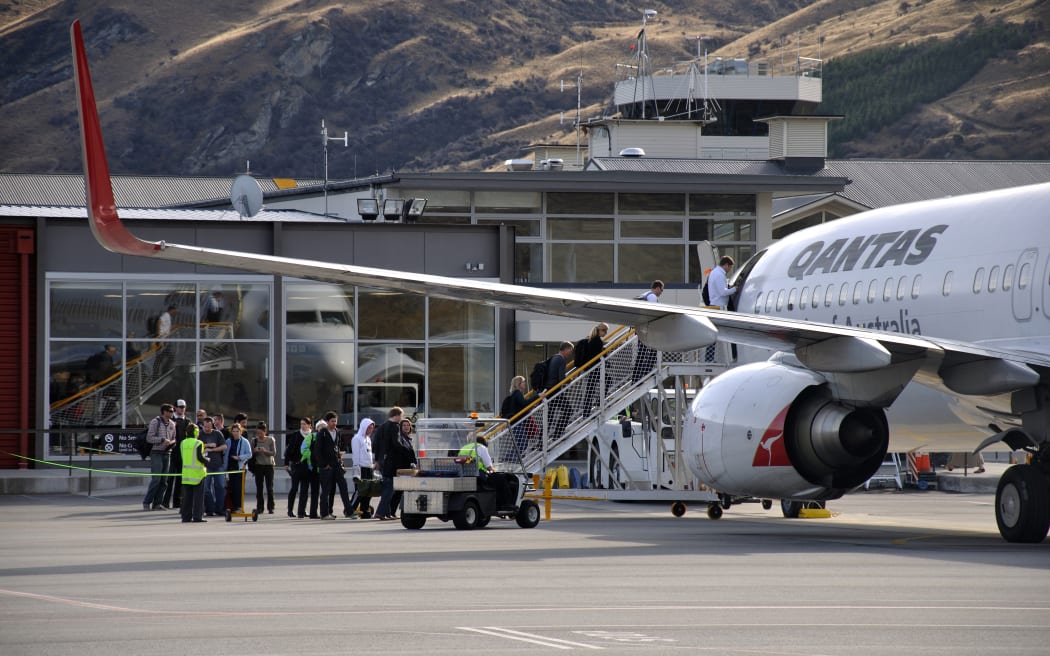 Passengers board commercial jet at Queenstown Airport.