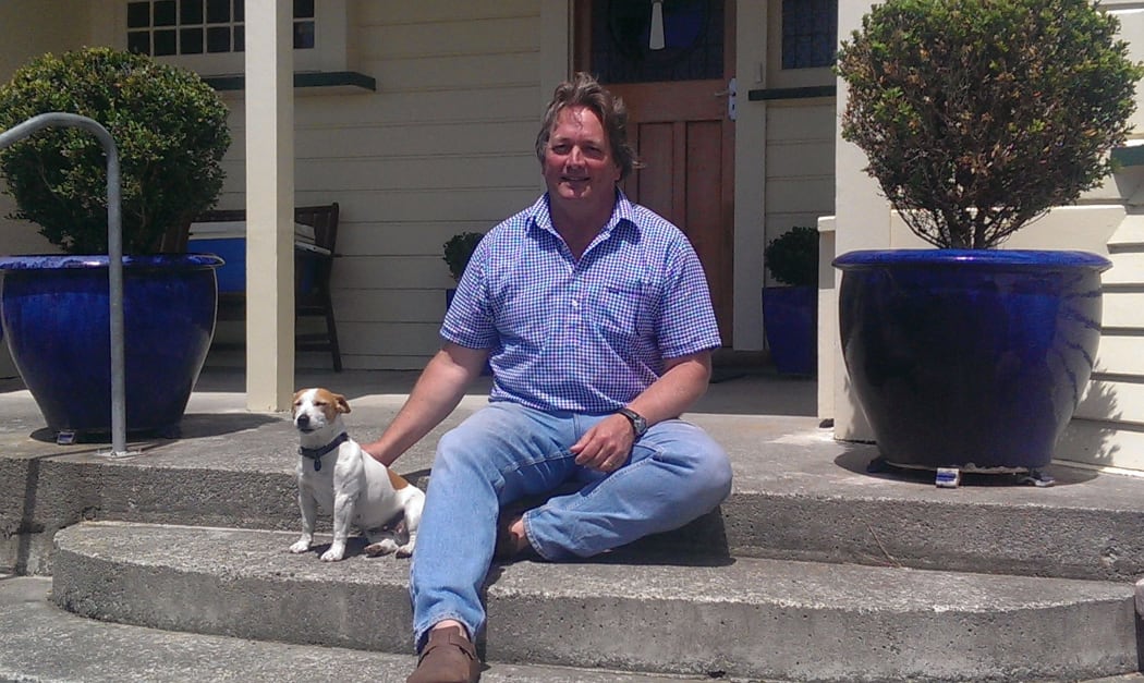 Anders Crofoot with his fox terrier on the front steps of his home