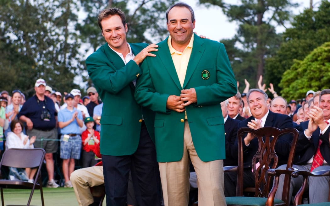 Angel Cabrera is presented with his green jacket by Trevor Immelman after winning the Masters in 2009.