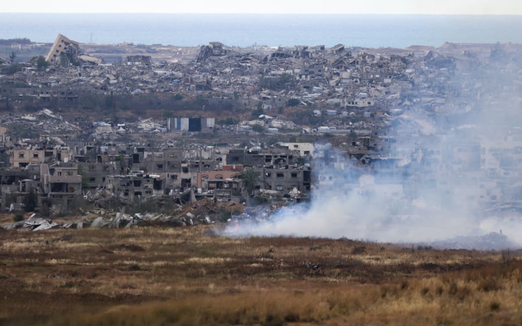 This picture taken from Israel's southern border with the Gaza Strip shows burning fields in front of destroyed houses in northern Gaza on May 4, 2025. Israel was issuing orders to call up tens of thousands of reservists ahead of an expanded offensive in Gaza, Israeli media reported on May 3, as Prime Minister Benjamin Netanyahu attacked truce mediator Qatar. (Photo by Menahem KAHANA / AFP)