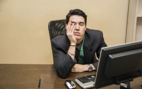 Man with head in hands in front of computer