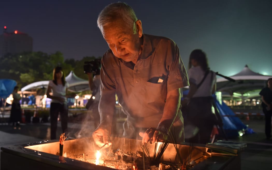 A man lights a fire in incense to pray for the victims of the 1945 atomic bombing, at the Peace Memorial Park in Hiroshima.