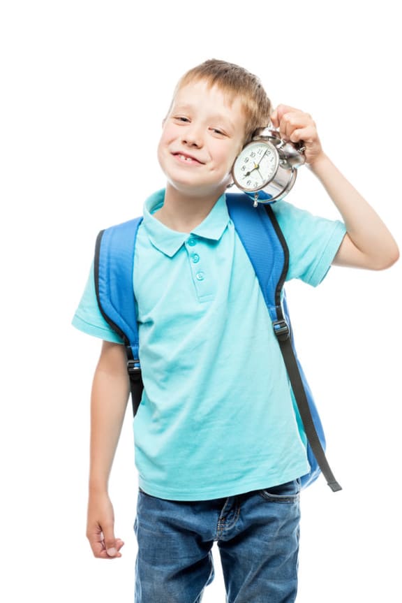 A photo of a schoolboy with an alarm clock