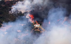A house is threatened as the Palisades Fire grows in the mountains in the community of Topanga, California, on 9 January 2025.
