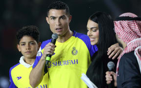 Portuguese forward Cristiano Ronaldo, accompanied by his partner Georgina Rodriguez and his son  (C-R) and his son Cristiano Jnr, greets the crowd at the Mrsool Park Stadium in the Saudi capital Riyadh on January 3, 2023, upon his presentation as an Al-Nassr player.