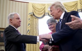 Jeff Sessions shakes hands with US President Donald Trump.