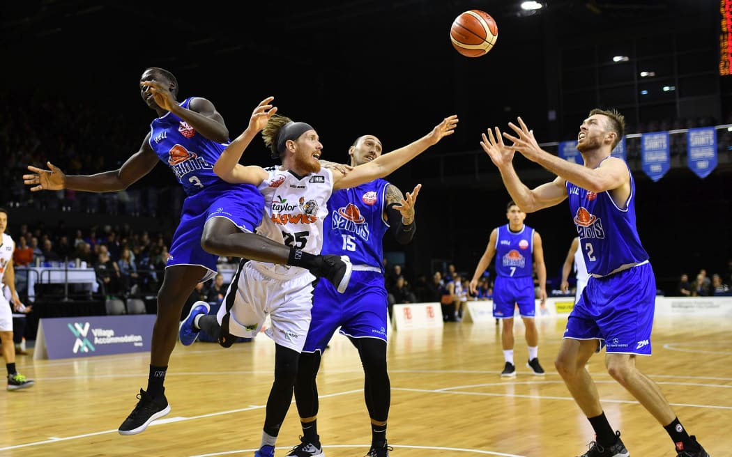 Hawks El Singler (Center L) has a shot intercepted by Saints Sunday Dench (L) and Leon Henry (Centre R) and drops into the hands of team mate Nick Kay during the NBL basketball match between the Wellington Saints and Hawkes Bay Hawks at the TSB Arena on Friday the 12th April 2019.