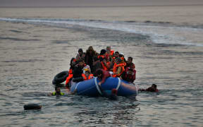 Refugees and migrants massed onto an inflatable boat reach Mytilene, northern island of Lesbos, after crossing the Aegean sea from Turkey last February.