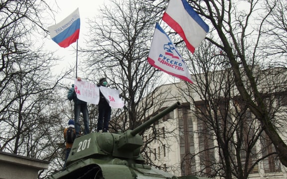 Pro-Russian demonstrators in front of the Crimean parliament holding placards saying "Crimea for peace".
