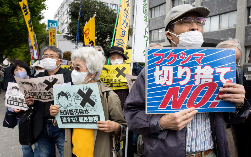 Demonstrators hold slogans during a protest outside the Japanese prime minister's office against the government's plan to release treated water from the Fukushima nuclear plant into the ocean, on April 13, 2021.