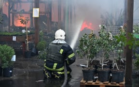 A Ukrainian firefighter extinguishes a fire at a hardware superstore following a Russian strike, in Kharkiv, on 25 May, 2024, amid the Russian invasion of Ukraine. Kharkiv regional governor Oleg Synegubov said at least two people were killed when two Russian guided bombs hit a construction hypermarket. (Photo by SERGEY BOBOK / AFP)