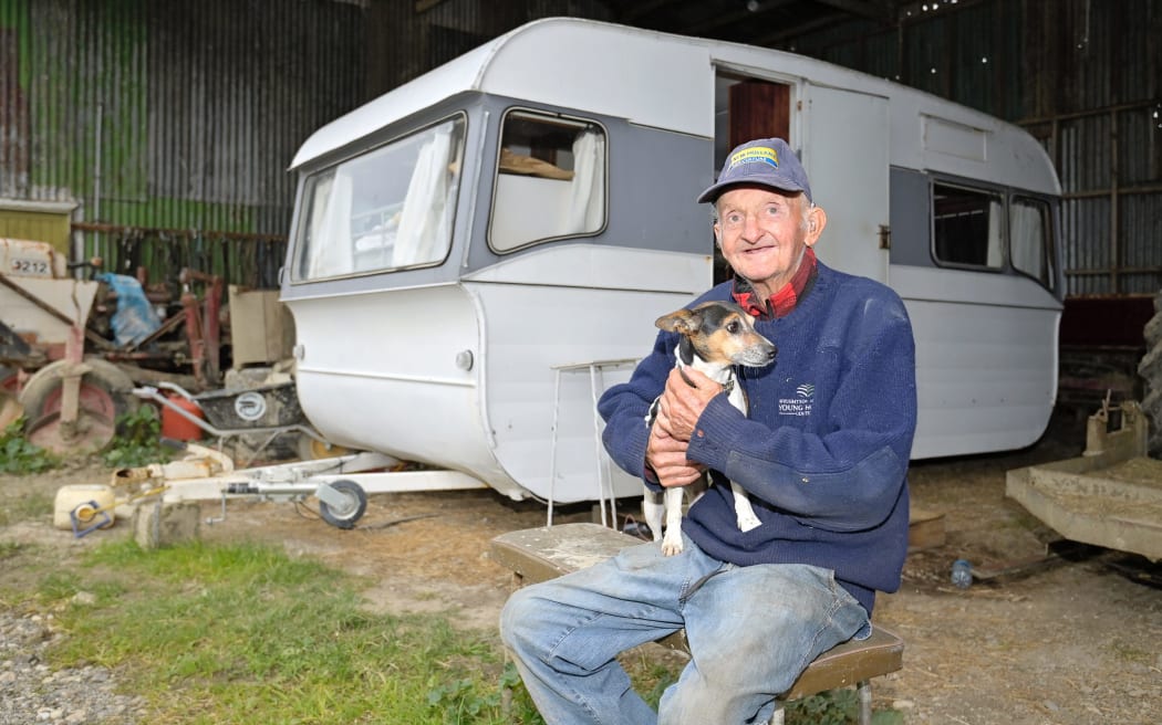 Jim Cowan with dog Bonnie outside their temporary home in Waipaoa. Following Cyclone Gabrielle, Cowan has been displaced from his home which was yellow stickered.