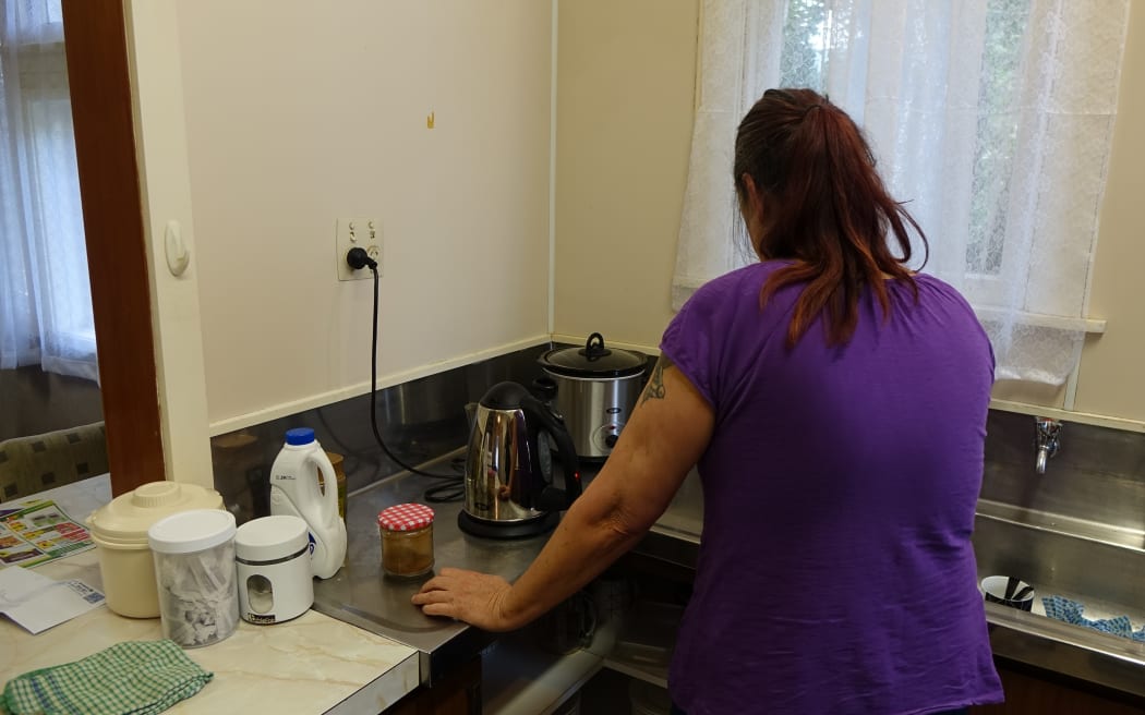 The woman, who does not want to be named, making a coffee in the emergency house.