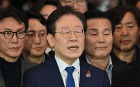 South Korea's main opposition Democratic Party leader Lee Jae-myung (C) speaks to the media at the National Assembly in Seoul on December 4, 2024, after South Korea President Yoon Suk Yeol declared martial law. - Yoon on December 3 declared martial law, accusing the opposition of being "anti-state forces" and saying he was acting to protect the country from "threats" posed by the North. (Photo by Jung Yeon-je / AFP)