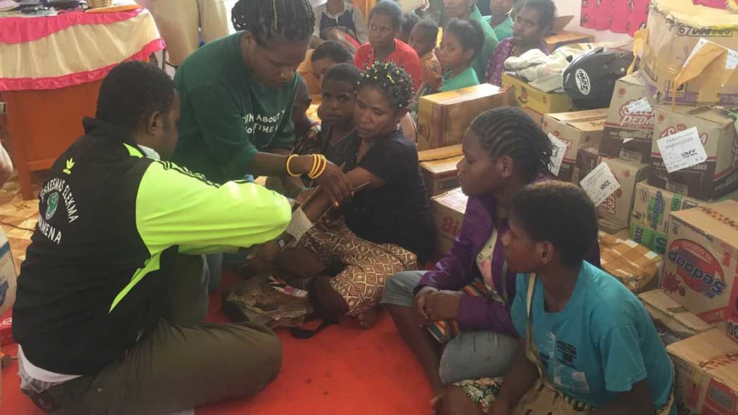 A volunteer doctor tends to a woman's broken arm, Wamena, Papua.