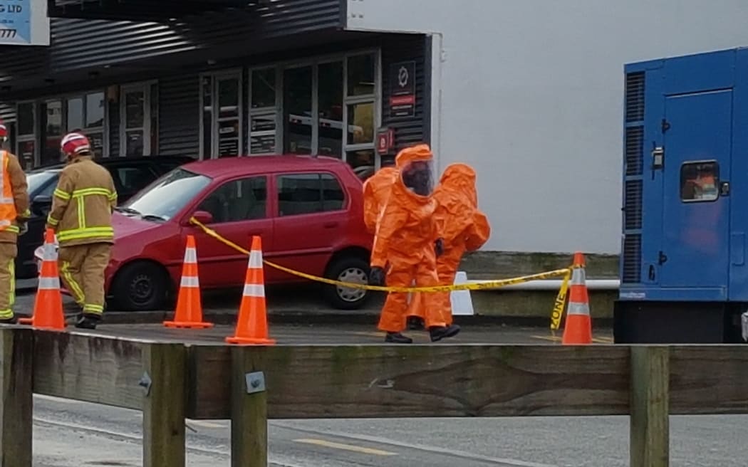 Firefighters in HAZMAT suits clean up at the site of the chemical spill in Wellington.