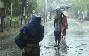 Residents walk along a street to a shelter ahead of the expected landfall of cyclone Amphan in Digha, West Bengal, on 20 May 2020.
