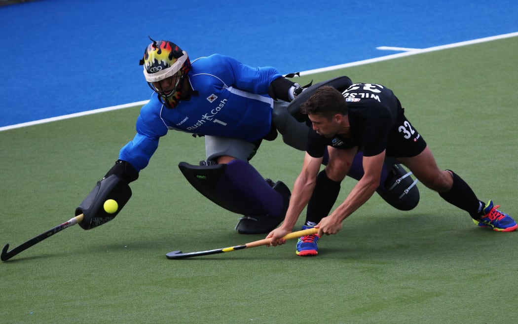 New Zealand's Nick Wilson tangles with Korea's goal keeper.