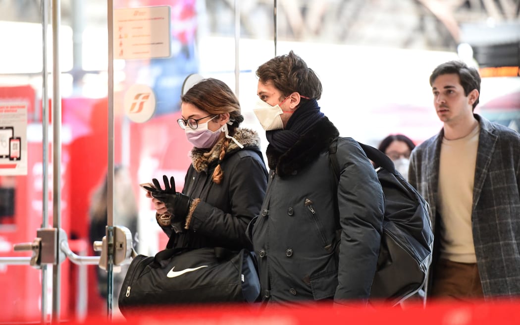 Passengers wearing protective face masks enter Milano Centrale railway station in Milan after millions of people were placed under forced quarantine in northern Italy.