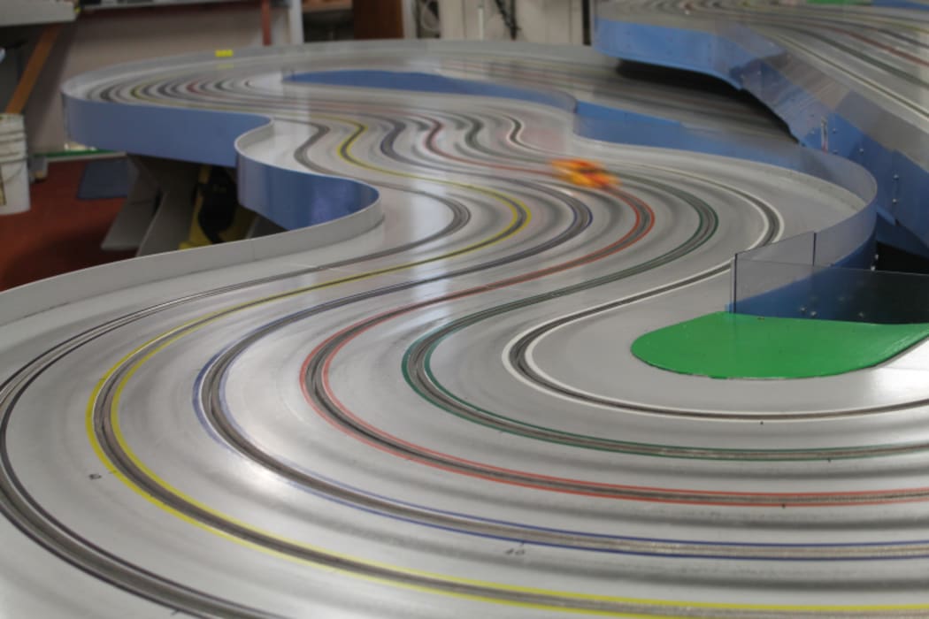 An image of a slot car racing around a track at high speed.