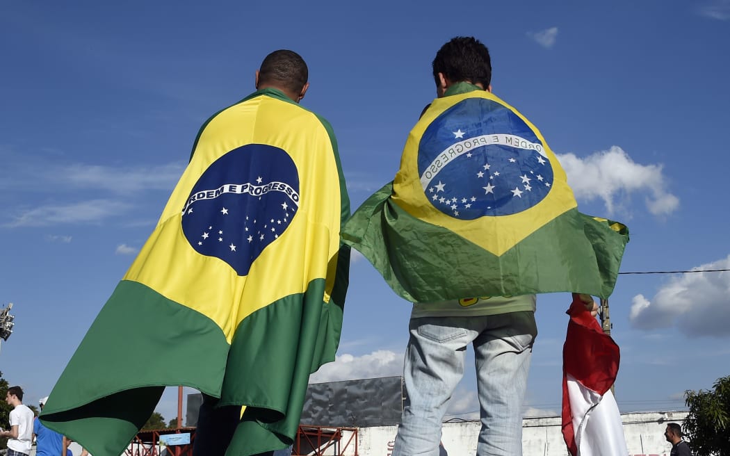 People wearing Brazilian flags arrive at the Santa Cruz Stadium.
