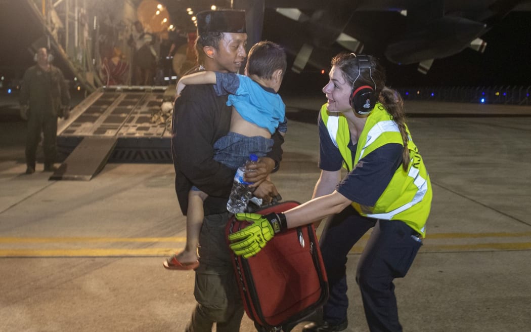 CPL Laura Kjestrup helps a family as they arrive at Balikpapan airport.