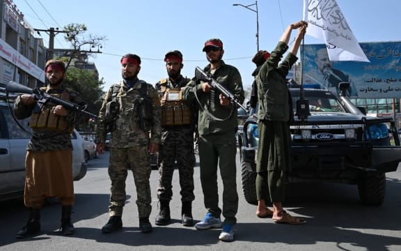 Taliban fighters stand guard along a road in Kabul on September 9, 2021. (Photo by WAKIL KOHSAR / AFP)