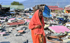 Quake survivor Nurhayati walks at an area where her house once stood in Lere subdistrict in Palu, Indonesia's Central Sulawesi.