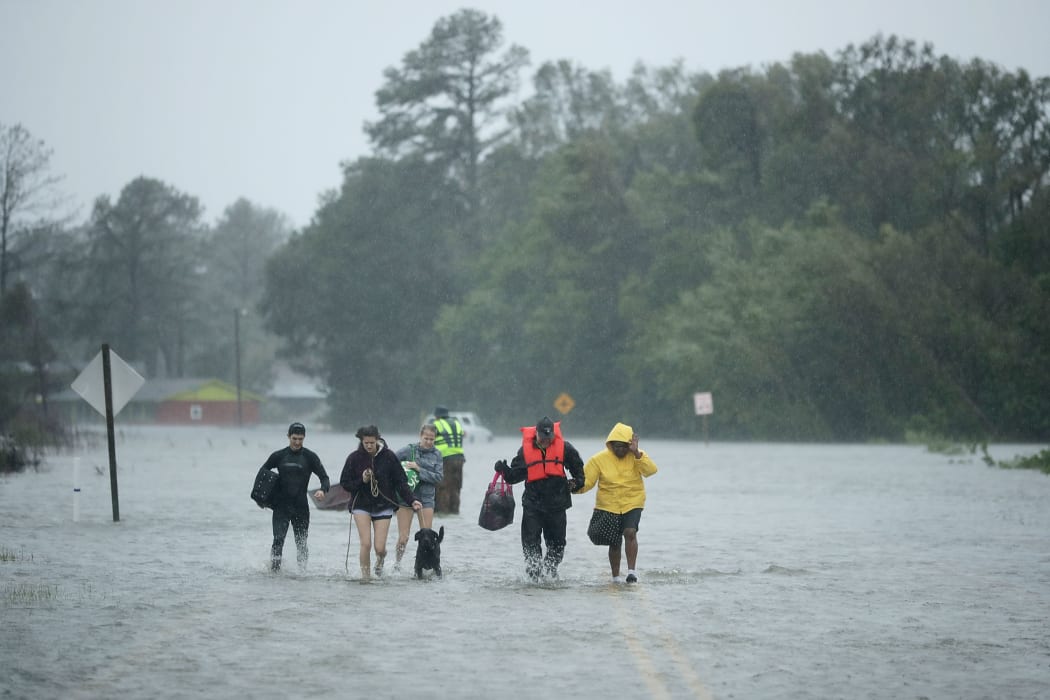 Volunteers from the Civilian Crisis Response Team help people to higher ground after rescuing them from their flooded homes during Hurricane Florence in James City, North Carolina.