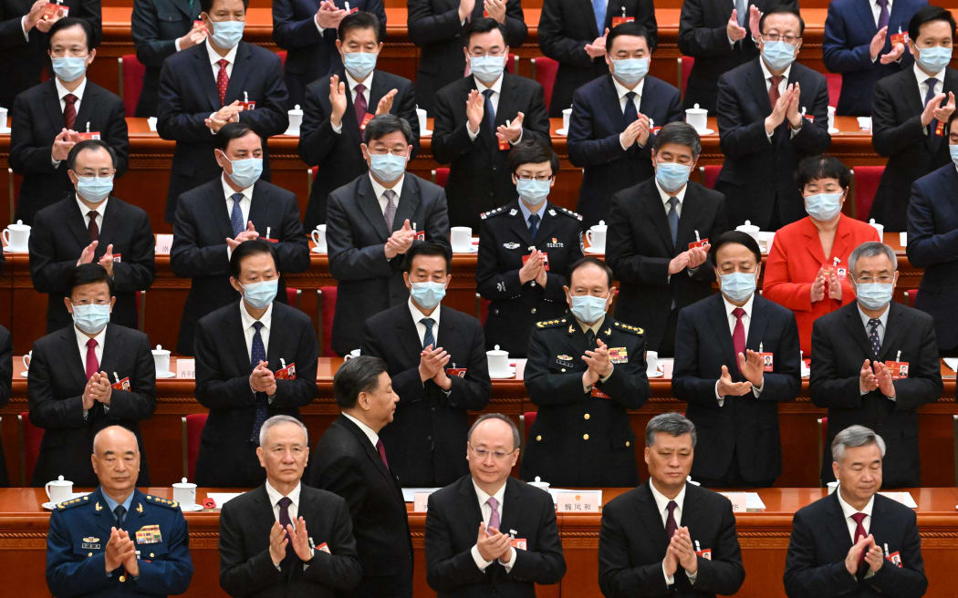 China's President Xi Jinping (bottom 3rd left) walks back to his seat after taking an oath as he is re-elected for a third term during the third plenary session of the National People's Congress in Beijing on 10 March, 2023.