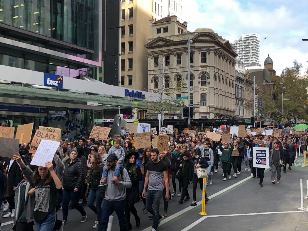 The Black Lives Matter protesters make their way down Queen Street in Auckland.