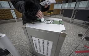 A voter casts their ballot in the House of Representatives election at a polling station in Tokyo on February 8, 2026. Japan voted in snap elections February 8 with Prime Minister Sanae Takaichi hoping to turn a honeymoon start into a resounding ballot box victory that could rile China and rattle financial markets. (Photo by Yuichi YAMAZAKI / AFP)