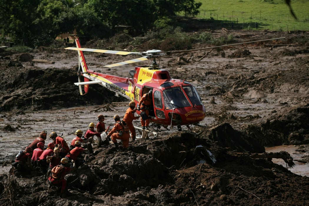 FILE - In this Jan. 28, 2019 file photo, firefighters are resupplied as they search for victims of the Vale dam collapse in Brumadinho, Brazil.